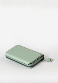 Groene leren portemonnee met een gladde textuur, rechthoekige vorm, ritssluiting en een leren ritslip. Eenvoudig ontwerp en minimale branding.