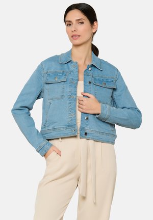 Hele sinine denimpusa, kus on kraed, ees taskud ja nööbid; omab lühikest disaini ja pikki varrukaid.
