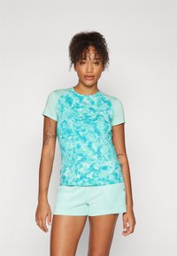 Top desportivo azul claro com um padrão texturizado e abstrato; combinado com calções a condizer. Ambos os itens apresentam um design ajustado e mangas curtas.