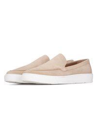 Zapatos de ante beige tipo slip-on con punta redonda, suela de goma blanca y un diseño minimalista, que no presentan cordones visibles ni marcas.