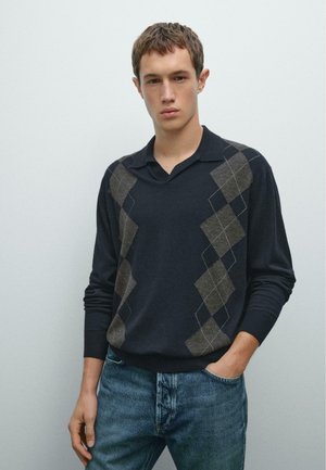 Navy long-sleeve polo sweater with a brown and gray argyle pattern across the front. Soft material, collar, and ribbed cuffs; paired with denim jeans.