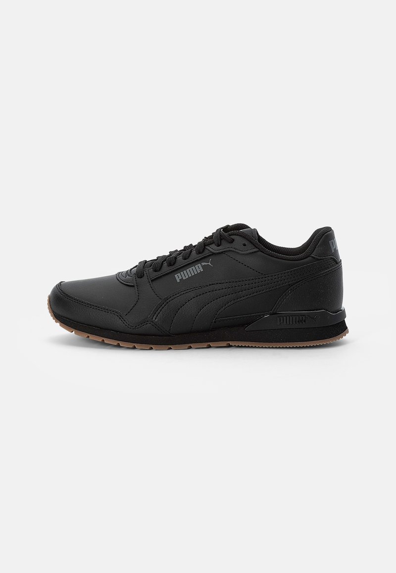 Baskets noires Puma avec design à lacets, semelle texturée et logo Puma sur le côté et le talon, présentées sur un fond blanc uni.