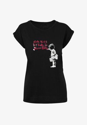 T-shirt noir avec un graphique d'une jeune fille tenant un seau, peignant "On n'est jamais trop jeune pour rêver grand" en lettres rouges et blanches.