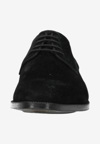 Zwarte suède veterschoenen met een gladde textuur, ronde neus en platte zwarte rubberen zool. Minimalistisch ontwerp zonder zichtbare branding.