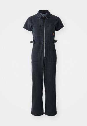 Combinaison en denim foncé avec col, manches courtes, fermeture éclair avant, deux poches poitrine et liens sur le côté à la taille.