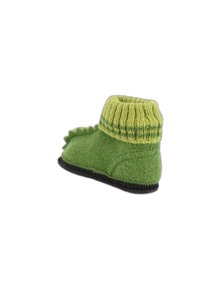 Groene wollen slipper met een ribbelige geel-groene boord en een zwarte zool, versierd met decoratieve spikes langs de hiel. Overall een gladde textuur.