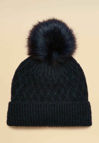 Black knitted beanie with a patterned texture, featuring a large black faux fur pom-pom on top and a ribbed cuff at the base.