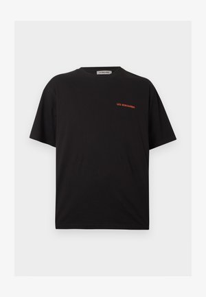 T-shirt noir à manches courtes avec col rond, avec un petit texte rouge "LES BENJAMINS" sur le haut du côté gauche de la poitrine.