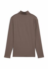 Langærmet polo-shirt i en ensfarvet brun farve. Har en klassisk krave og en glat tekstur uden synlige mønstre eller accenter.
