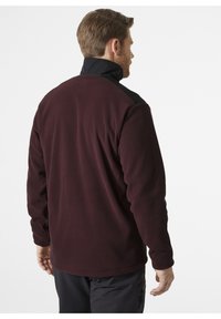Bordowy polarowy sweter z czarnym kołnierzykiem; gładka faktura; długie rękawy; miękki materiał; brak widocznych logo lub wzorów.