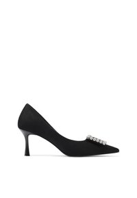 Scarpa con tacco alto in suede nero con punta affusolata e tacco sottile. Presenta una fila decorativa di gemme trasparenti sul lato superiore.
