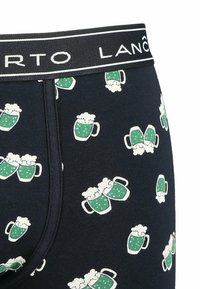 Męskie slipy w granatowym kolorze z motywem zielonych kufli piwa z białą pianką. Elastyczny pas z logo marki.