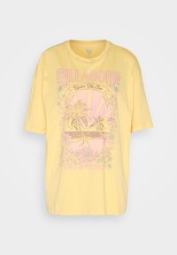 Camiseta de algodón amarilla con un diseño gráfico rosa de palmeras y flores, con el texto "BILLA BONG" y "gira de 1973" en una fuente retro.