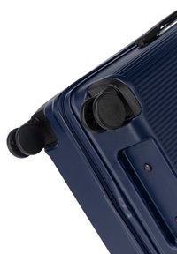 Temně modrý tvrdý kufr s texturovaným povrchem, vybavený dvěma černými kolečky a zipovým uzavřením. Kompaktní design s zaoblenými hranami.