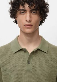 Polo shirt verde in maglia con pattern testurizzato, dotato di colletto classico e placca a due bottoni, progettato per una silhouette aderente.
