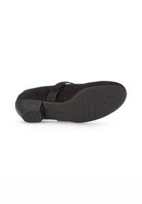 Chaussure en daim noir à talon bas, avec un bout rond et une sangle unique sur le dessus. Semelle en caoutchouc texturée avec des détails de crampons.