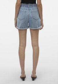 Denimshorts med en fransad fåll, ljusblå färg, elastisk midja och två bakfickor. Slät textur och avslappnad design.