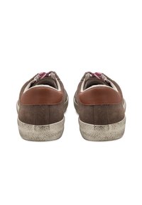 Zapatillas de ante marrón con una suela de goma blanca texturizada y detalles de cuero marrón en el talón. El interior tiene un patrón rosa.
