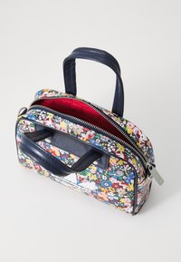 Bolso con estampado floral, con asa y ribetes de piel sintética azul marino. Cuenta con dos compartimentos con cremallera y un forro interior de color rojo brillante.