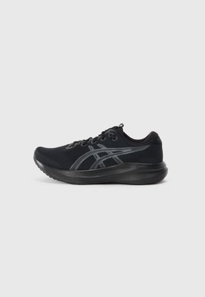 Chaussure de sport noire avec tige en maille, bout texturé et semelle épaisse. Présente des accents gris et un design classique à lacets pour un maintien sécurisé.