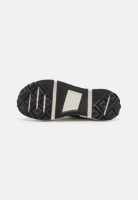 Zool van zwart-wit Converse All Star-schoenen met een gestructureerde grip en logo in het midden op een witte achtergrond.
