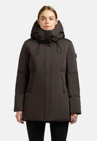 Piumino marrone con colletto alto e cappuccio ampio, dotato di coulisse regolabile e tasche laterali. Tessuto liscio e isolato.