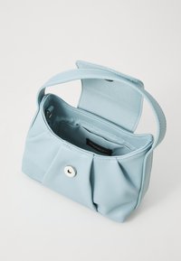 Lichtblauwe kleine handtas met een enkele strap, open klep, magnetische drukknop en zichtbare binnenzak op een witte achtergrond.