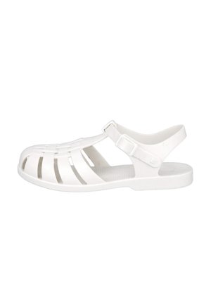 Sandal de plástico blanco con punta abierta, diseño superior trenzado, correa ajustable en el tobillo y plantilla texturizada. Estilo clásico y ligero.