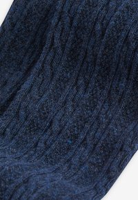 Dunkelblauer strukturierter Pullover aus gestricktem Stoff, mit einem Wellenmuster und unterschiedlichen Dicken im Material.