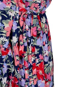 Květinové šaty s plisovaným designem. Hlavní barvy zahrnují námořnickou modř, červenou, růžovou a zelenou. Jemná, texturovaná tkanina s detailem zavázaného pasu.