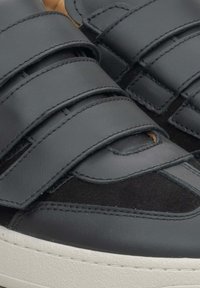 Czarne sneakersy wykonane z materiałów skórzanych i zamszowych, z rzepami, białą gumową podeszwą i przeszyciami. Gładkie i teksturowane wykończenia.