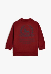 Czerwony sweter z wysokim kołnierzem, z niebieskim nadrukowanym herbem lwa i napisem: "Royal Champs Original Golf Club California." Materiał mieszany bawełniany.