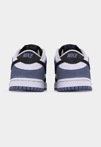 Ζευγάρι χαμηλά αθλητικά παπούτσια Nike, που φαίνονται από πίσω, με λευκό, μαύρο και γκρι-μπλε χρώμα και λογότυπο Nike στις ταμπέλες της φτέρνας.