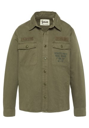 Olijfgroene blousejas met borstzakken, patches met de tekst "US 740 N" en "SCHOTT NYC," en bedrukt tekst op de rechterzak.