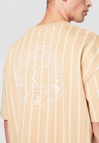 Karl Kani CHEST SIGNATURE BOXY PINSTRIPE TEE - Triko s potiskem - sand/white