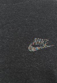Mörkgrå sweatshirt med en texturerad, mångfärgad glittrande Nike-logotyp på bröstet. Mjukt tyg med klassisk rund halsringning.