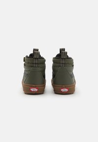 Grønne høyhælte sneakers med polstret krage, svarte detaljer og en teksturert gummisåle. Har to løftestropper på hælen og side-striper.