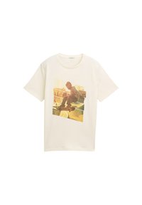 Camiseta de algodón blanca con un gran estampado gráfico de un skater en acción, en una paleta de colores en tonos amarillos y marrones desvaídos.