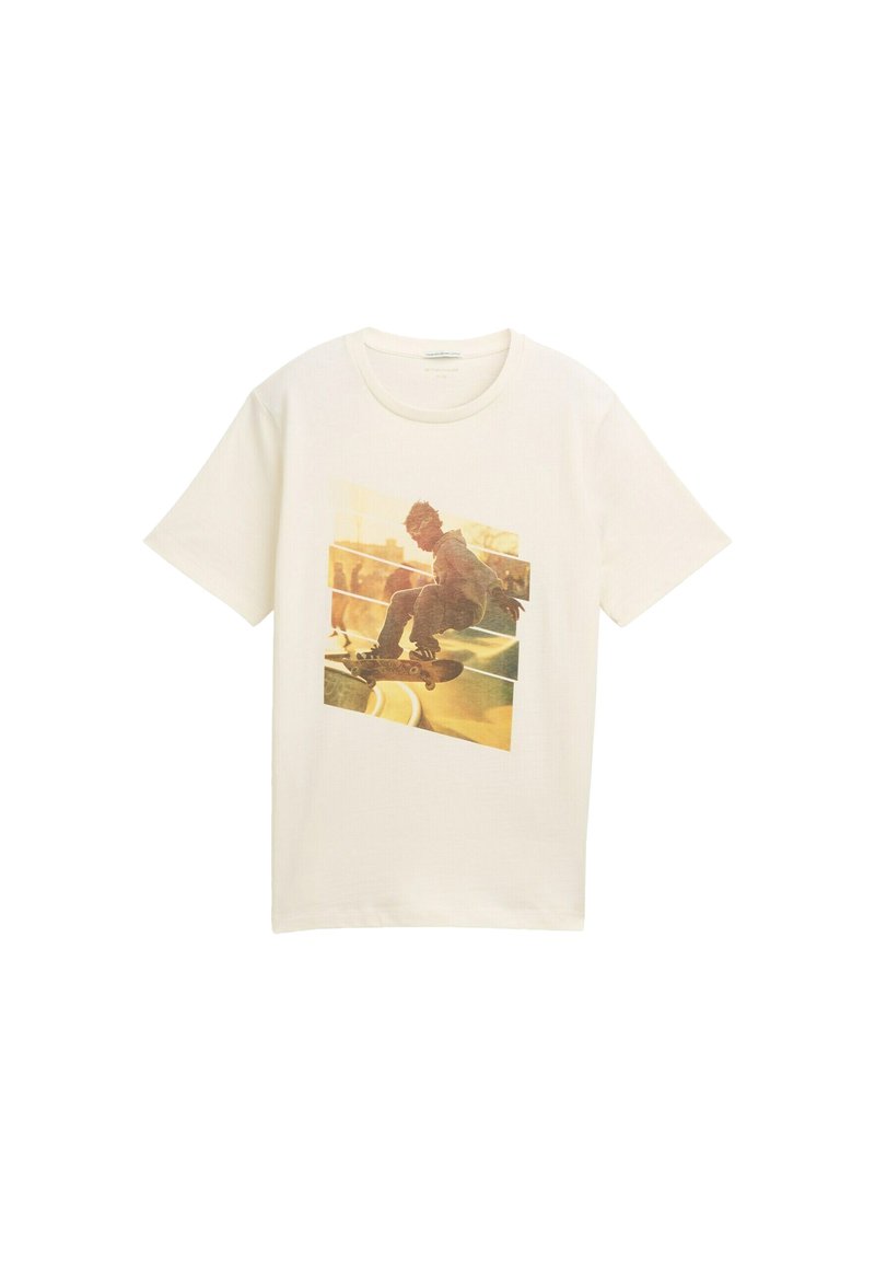 Camiseta de algodón blanca con un gran estampado gráfico de un skater en acción, en una paleta de colores en tonos amarillos y marrones desvaídos.