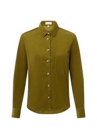 Camicia in velluto a coste verde oliva con colletto a punta, chiusura frontale con bottoni e una tasca sul petto. Maniche lunghe con polsini abbottonati.