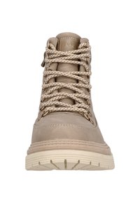 Botte montante beige en matériau synthétique texturé, lacets beige et blanc à motifs, œillets renforcés et semelle en caoutchouc crème claire.
