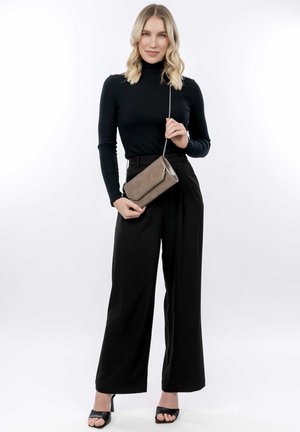 Musta ribbed turtleneck, korkeavyötäröiset mustat housut ja avonaiset mustat korot. Kädessä suorakulmainen, taupevärinen olkalaukku, jossa on ketjuhihna.