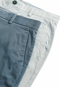 Dos pares de pantalones: uno gris claro y otro azul oscuro. Ambos tienen una textura suave, un frente plano y una cinturilla estándar con un botón.