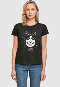 Black cotton t-shirt featuring a large white graphic of a face with iconic hair and exaggerated features, labeled "Ozzy Osbourne" below.