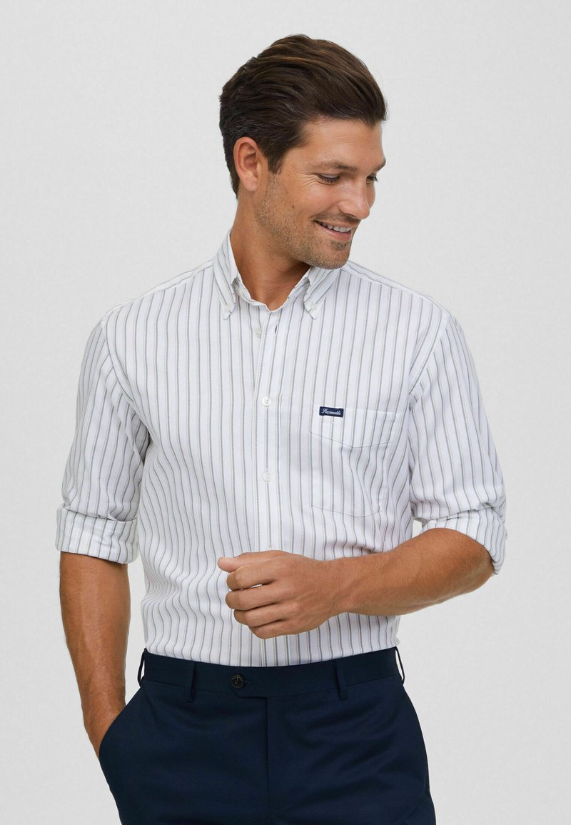 Witte button-down shirt met blauwe verticale strepen, korte opgerolde mouwen en een borstzak met een klein marineblauw etiket.