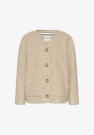 Bež teksturirana jakna z v-izrezom, sprednjimi žepi in petimi gumbi. Okranjena z svetlo obrobo okoli robov.