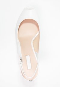 Scarpe aperte bianche in pelle con soletta beige, cinturino alla caviglia con fibbia in argento e finitura liscia. Design pulito e moderno.