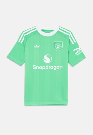 Vihreä jalkapallopaita, jossa on valkoisia yksityiskohtia, lyhyet hihat ja kolmonen raitamalli. Mukana Manchester Unitedin tunnus ja "Snapdragon"-logo.