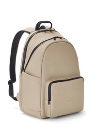 Beige hátizsák fekete cipzár kiegészítőkkel, párnázott pántokkal, tetején fogantyúval és egy elülső cipzáras zsebbel, fehér háttér előtt.