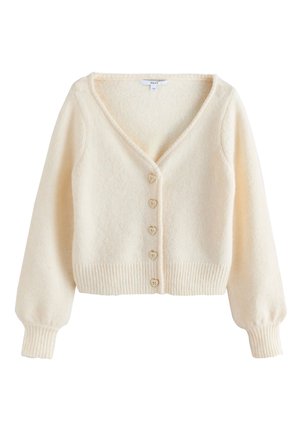 Krém színű, bolyhos kardigán hosszú puffos ujjakkal, V-nyakkivágással, bordázott szegéllyel és mandzsettákkal, valamint öt szív alakú gombbal az elején.